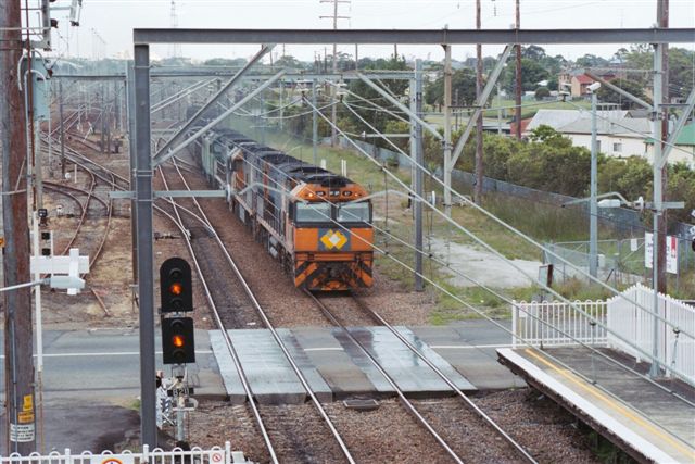 The view looking north towards Broadmeadow. Boradmeadow Yard is visible in the left distance. The partly lifted track in the left foreground is the former Down Relief line.