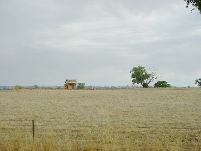 
The station is substantially intact in the middle of a field.  This view shows
the platform, shelter and water tank.  The mound on the right is the back of
the former goods loading bank.
