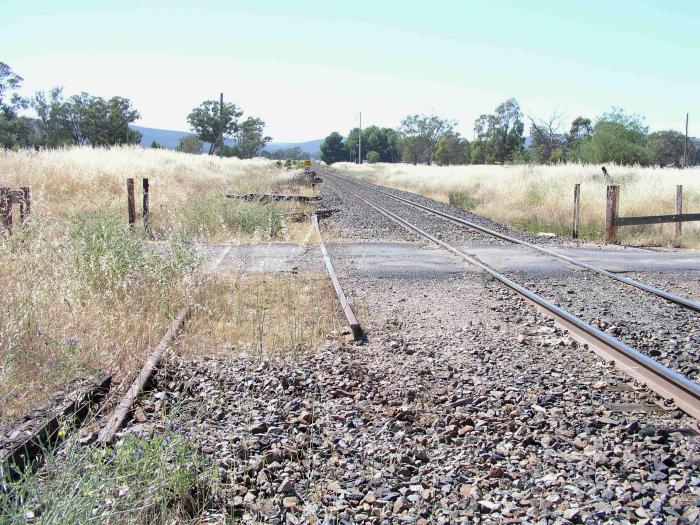 
The view looking back up the line, showing the remnants of the old loop
siding.  The platforms were located on either side of the lines just
beyond the level crossing.
