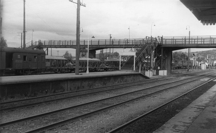 
A ballast train leaves the station under the footbridge.
