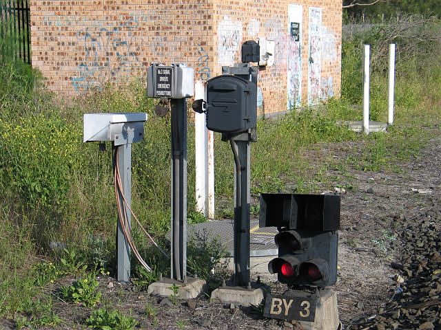 
Various safeworking equipment including signal BY3, the driver's emergency
pushbutton for the same, and a telephone.  The Botany relay and traffic room
is in the background.  This is at the up end of the Gelco sidings.
