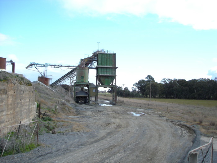 The gravel siding is now buried under the road, with the main line hidden under grass.