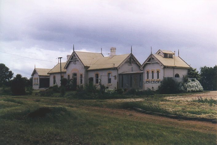 
Jerilderie station on a rather overcast day.  The station building is
apparently being used as a private residence.  Behind the building lies the
abandoned yard.
