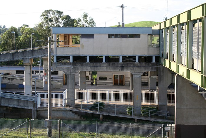 Looking north from the Macarthur Square complex towards the station, showing the overhead bridge and a train terminated in platform 1. Campbelltown is to the right.