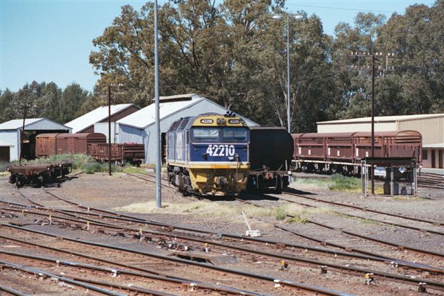 Locomotive 42210 and various wagons sit idle in the yard.