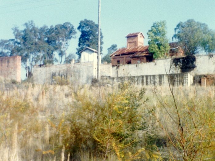 A view looking across to the site of the screens taken from the site of the rail sidings. The brick piers were the supports for the screens, and the brick building was the haulage house for the mine's endless rope skip haulage system.