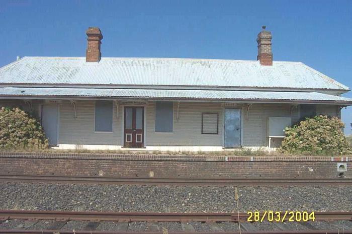 
The track-side view of the boarded up station building.
