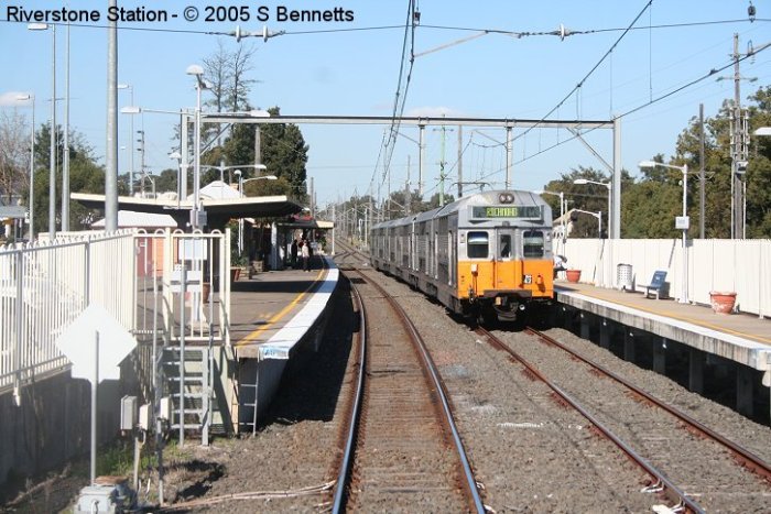 A view from an approaching up train, showing 6 car R+ set 42 waiting for the road to continue its run to Richmond.