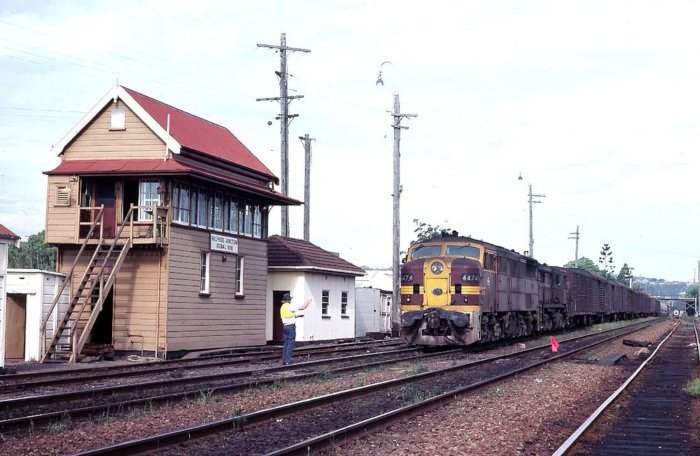 A goods train headed by 4474 and 4851 is about to exchange staffs outside the Sulphide Junction signal box. The train appears to be running "wrong road" on the Down Main.