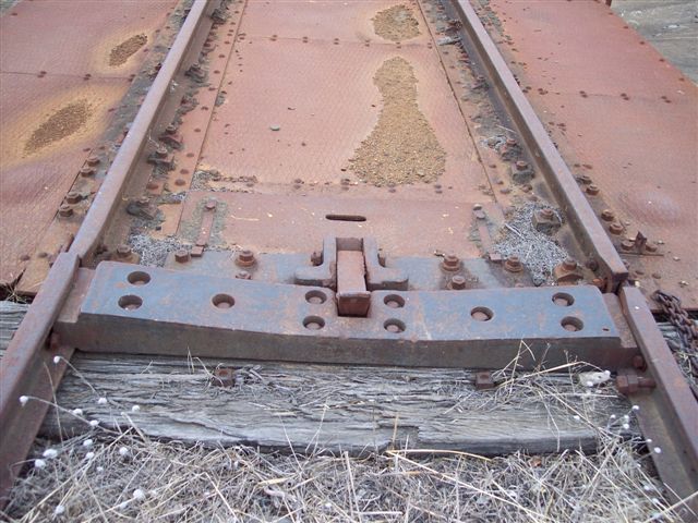 The locking pin at one end of the turntable deck.
