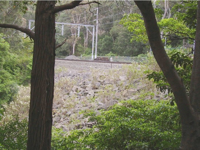 In many parts between Otford and Thirroul the Illawarra line winds a precarious course along the escarpment.  At Wombarra the escarpment is unstable and prone to land slips after heavy rain necessitating reinforcement - the view from the Wollongong end of the down platform showing the rock reinforcement.