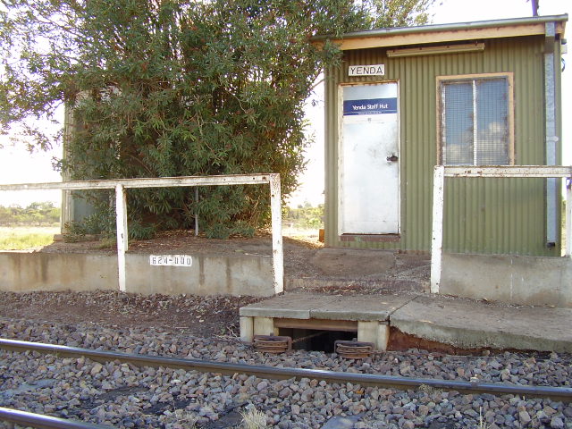 Accommodation for train staff is basic at Yenda, just the staff hut and a toilet behind the tree, which also hides the station name sign.